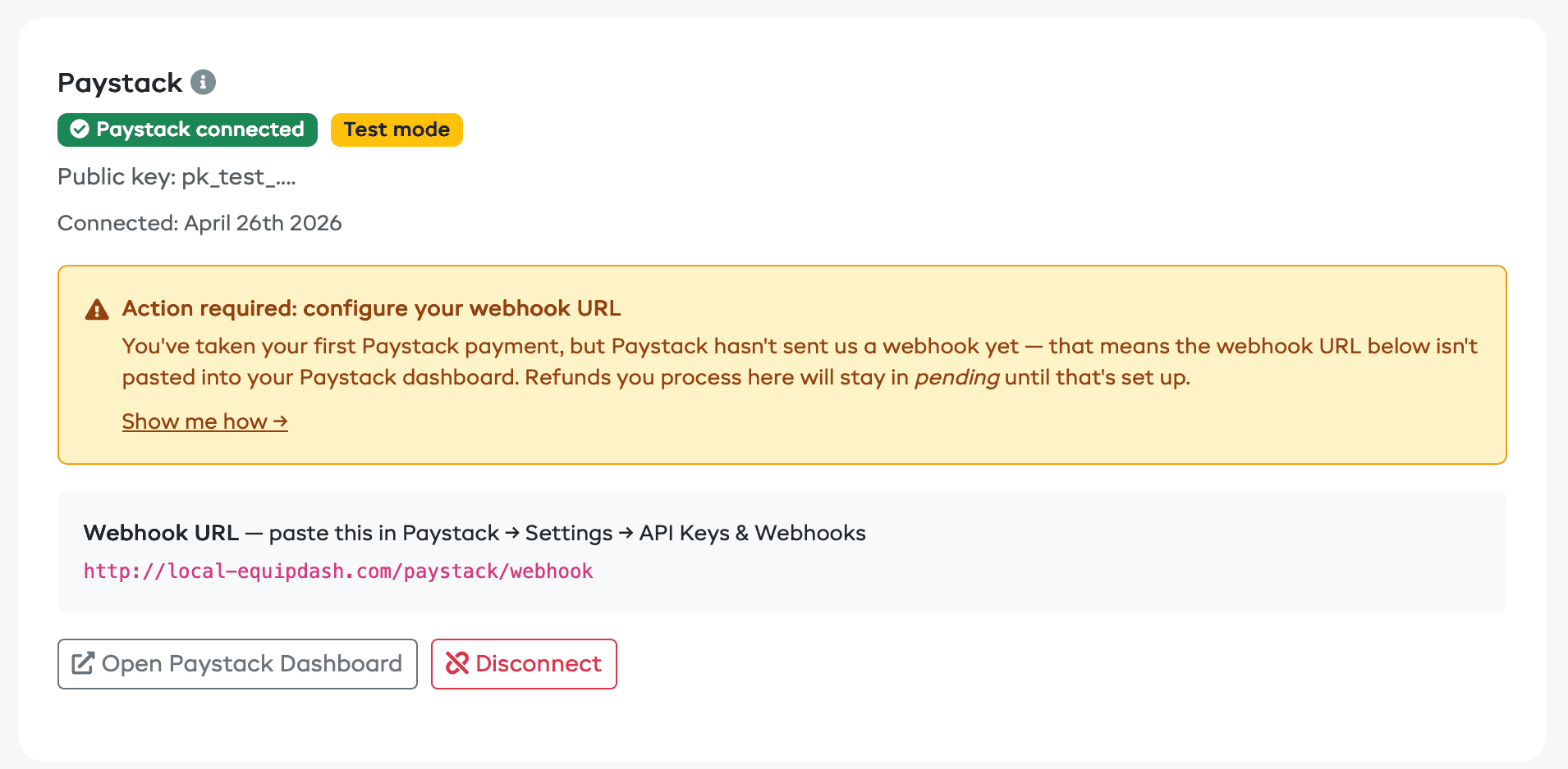 The connected Paystack card showing the webhook URL and the Action required nudge