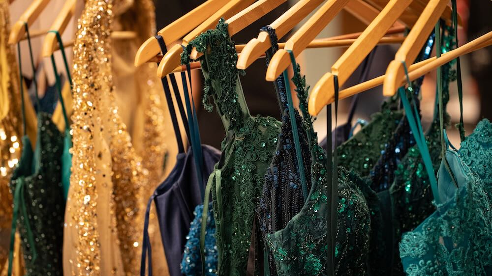 Formalwear rental floor with garment rails and a fitting in progress