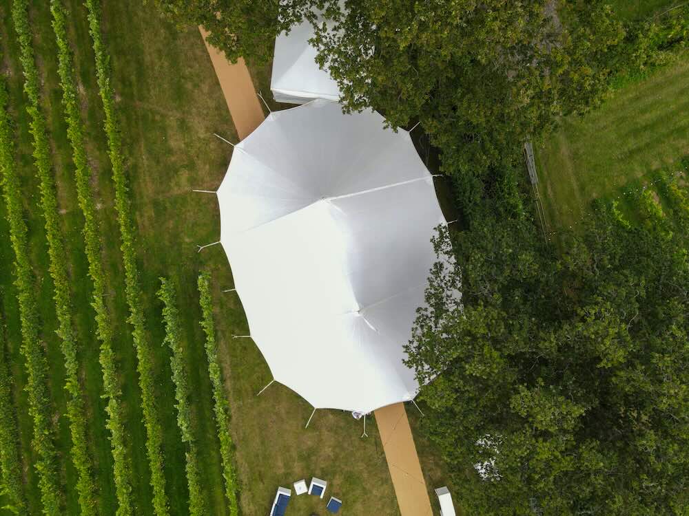 Crew erecting a frame marquee outdoors ahead of an event