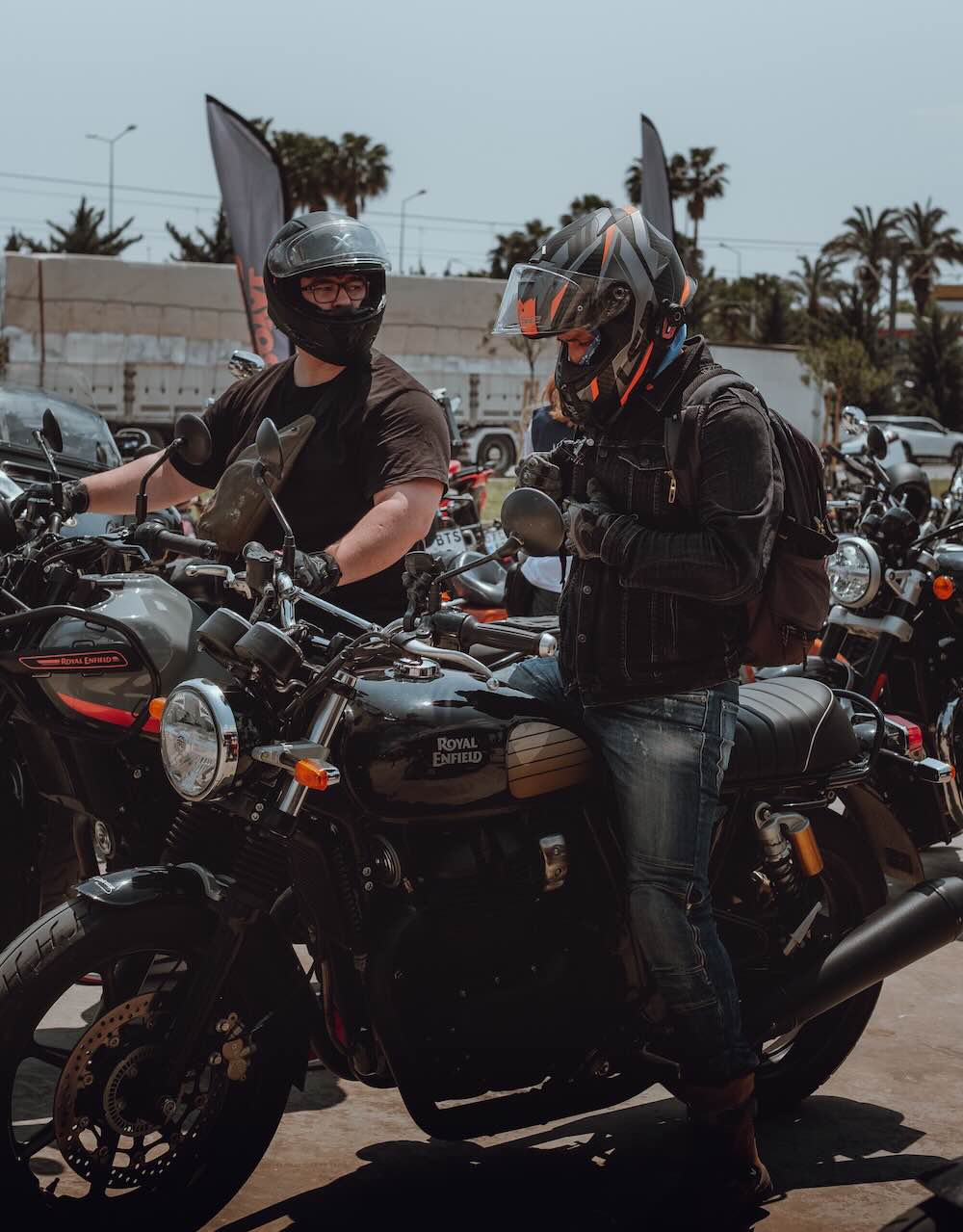 Motorcycle rental handover, rider collecting a bike with helmet in hand