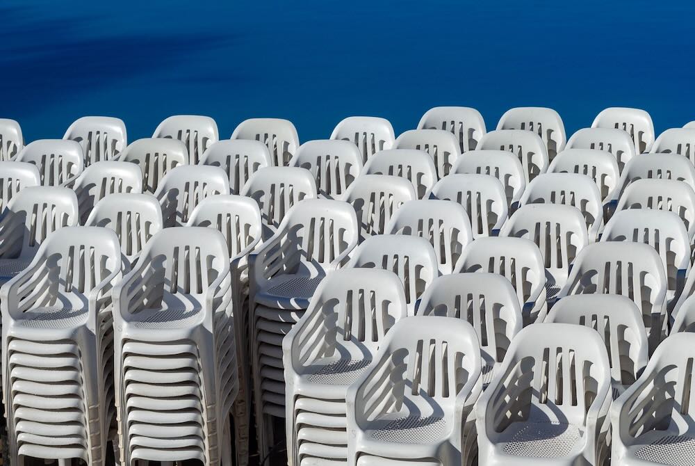 Warehouse racks of stacked banquet chairs and round tables