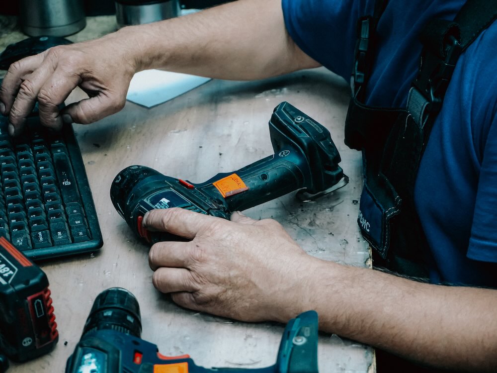 Tool rental counter handing power tools to a customer